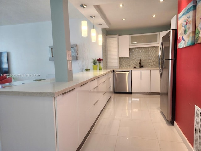 kitchen with white cabinetry, decorative light fixtures, light tile patterned floors, stainless steel appliances, and backsplash