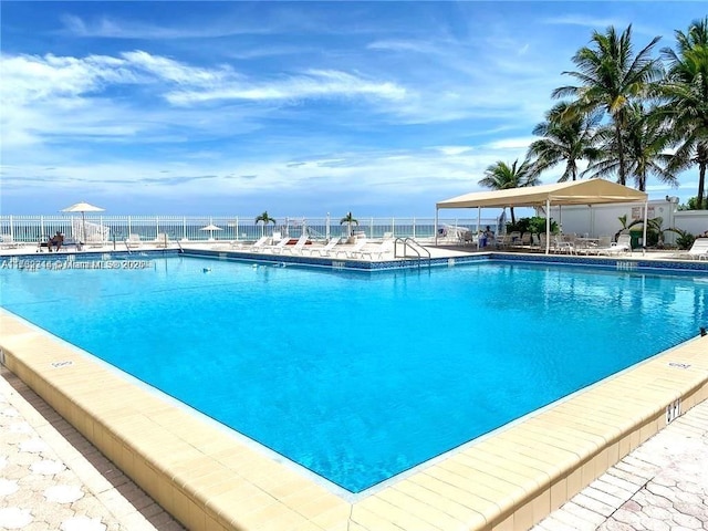 view of swimming pool featuring a patio and a water view