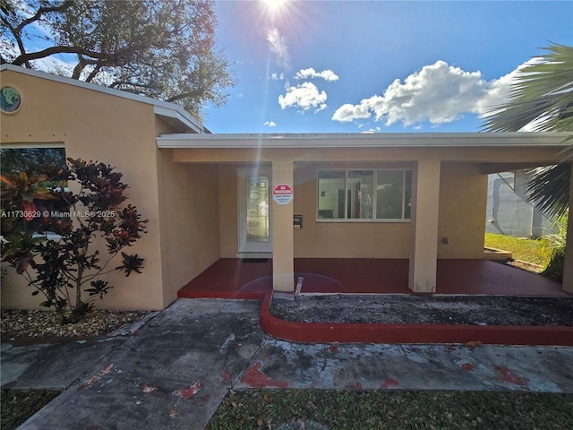 view of exterior entry with a carport