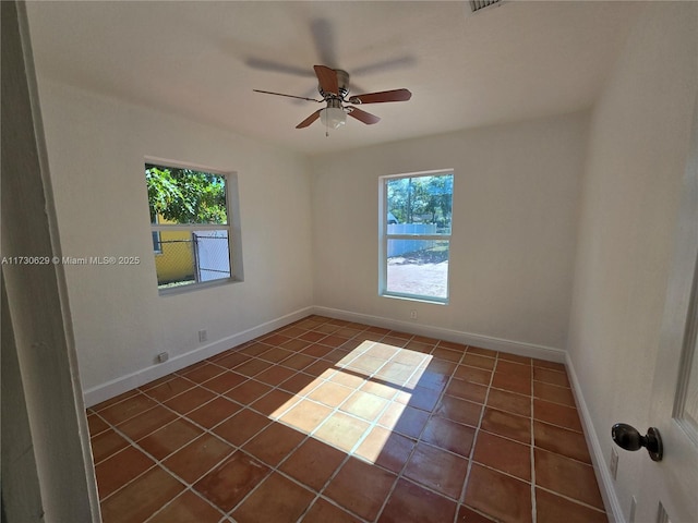 tiled spare room with ceiling fan