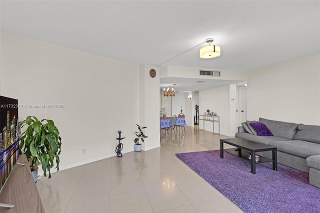 living room with a notable chandelier and light tile patterned flooring