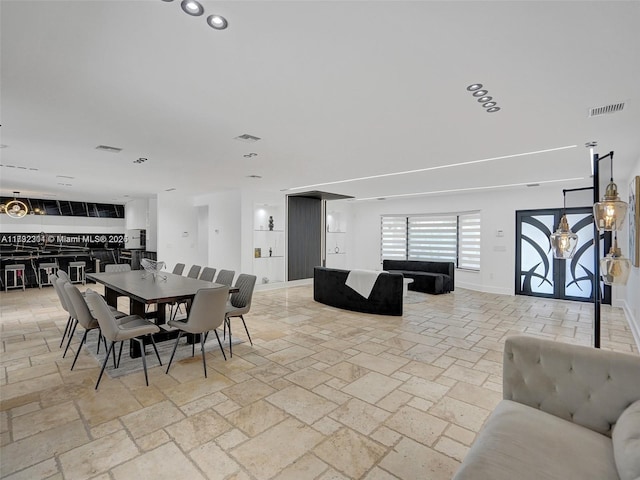 dining room with visible vents, stone tile flooring, and baseboards