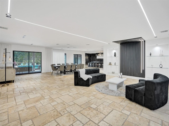 living room with visible vents and stone tile flooring