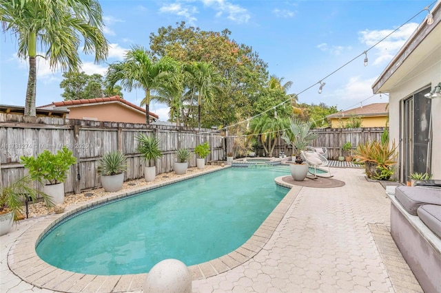 view of swimming pool featuring an in ground hot tub and a patio