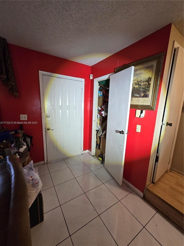 interior space featuring light tile patterned flooring and a textured ceiling