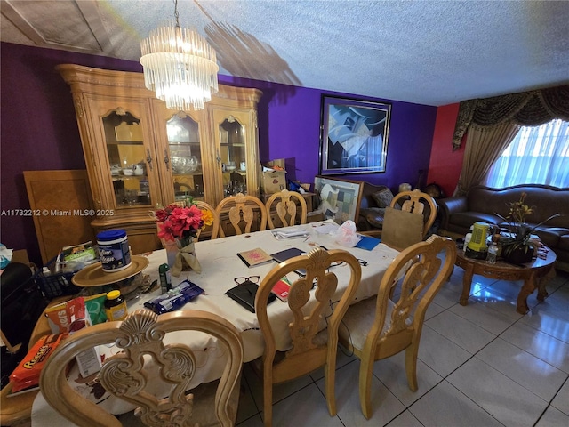 tiled dining room with a chandelier and a textured ceiling