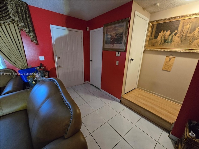 entryway with a textured ceiling and light tile patterned flooring