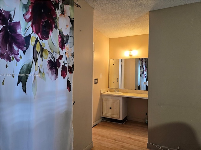 bathroom with vanity, wood-type flooring, and a textured ceiling