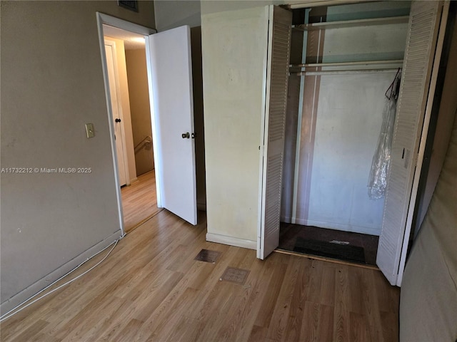 unfurnished bedroom featuring a closet and light wood-type flooring