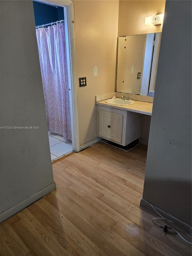 bathroom featuring hardwood / wood-style flooring, vanity, and walk in shower