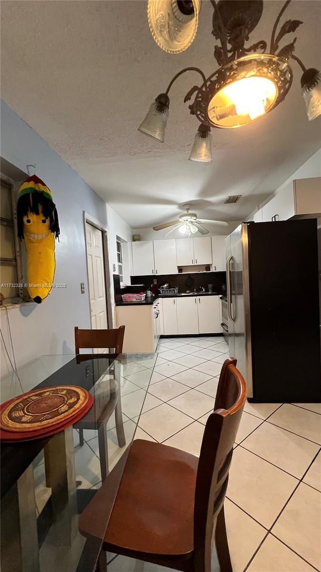 dining area featuring light tile patterned flooring, a textured ceiling, and ceiling fan