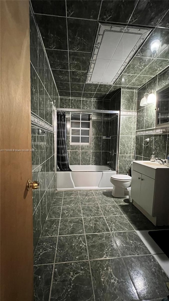 full bathroom with tile walls, vanity, toilet, and shower / tub combo with curtain