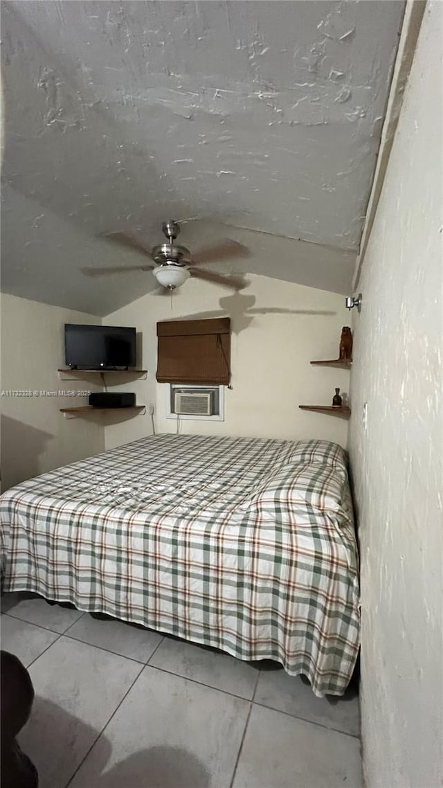 unfurnished bedroom featuring cooling unit, ceiling fan, lofted ceiling, and tile patterned flooring