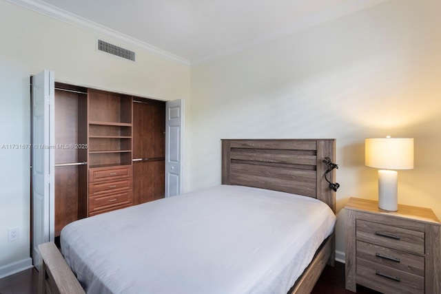 bedroom with ornamental molding, dark hardwood / wood-style flooring, and a closet