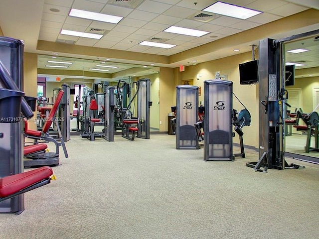 exercise room featuring a drop ceiling and light colored carpet