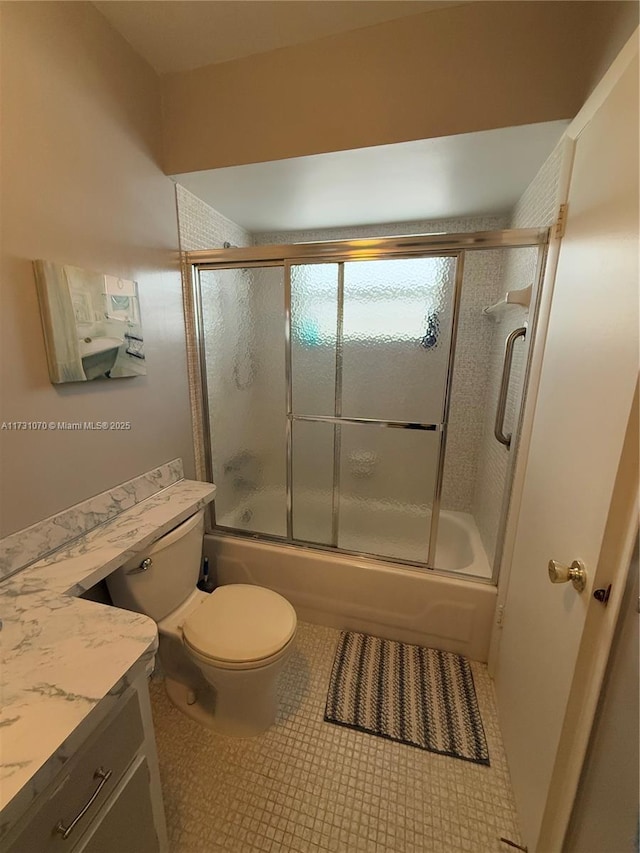 bathroom featuring bath / shower combo with glass door, vanity, toilet, and tile patterned floors