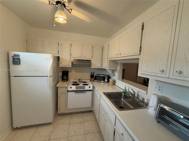 kitchen with white appliances, light tile patterned floors, light countertops, under cabinet range hood, and a sink