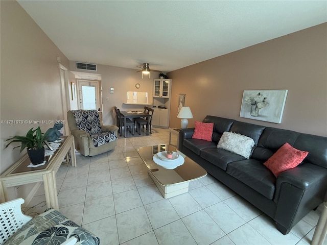 living area featuring light tile patterned floors, visible vents, and a ceiling fan