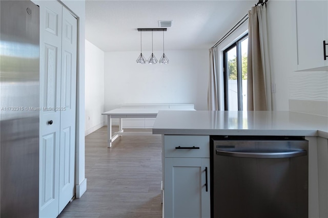 kitchen featuring pendant lighting, dishwasher, hardwood / wood-style floors, white cabinets, and kitchen peninsula