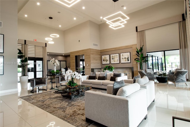 tiled living room featuring a towering ceiling and an inviting chandelier