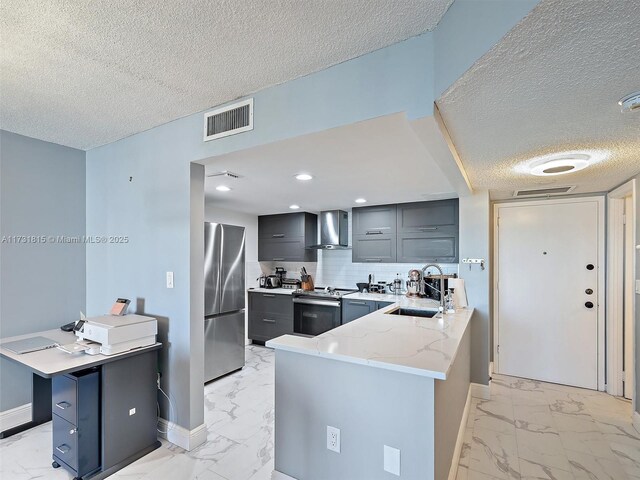 kitchen featuring wall chimney exhaust hood, sink, appliances with stainless steel finishes, kitchen peninsula, and decorative backsplash