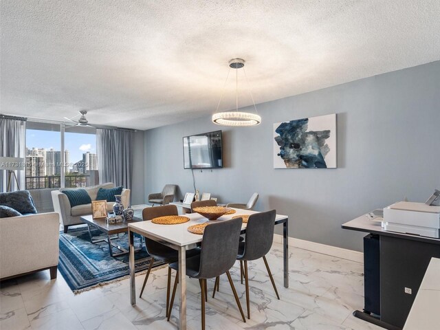 dining area with ceiling fan, a wall of windows, and a textured ceiling