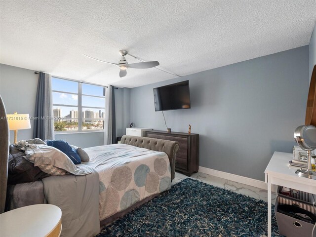 bedroom with a textured ceiling and ceiling fan