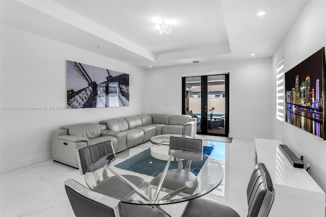 living room featuring a raised ceiling and french doors