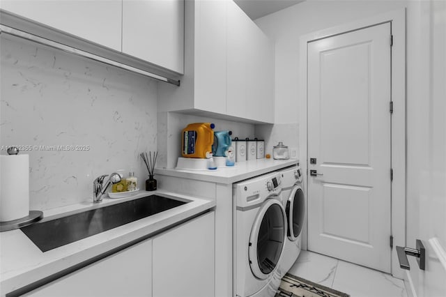 laundry room with cabinets, independent washer and dryer, and sink