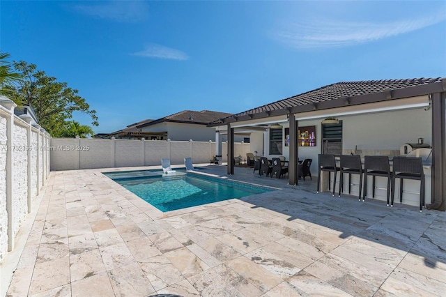 view of swimming pool featuring a patio area and an outdoor bar