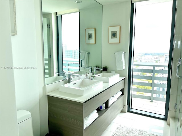 bathroom with tile patterned flooring, vanity, floor to ceiling windows, and toilet