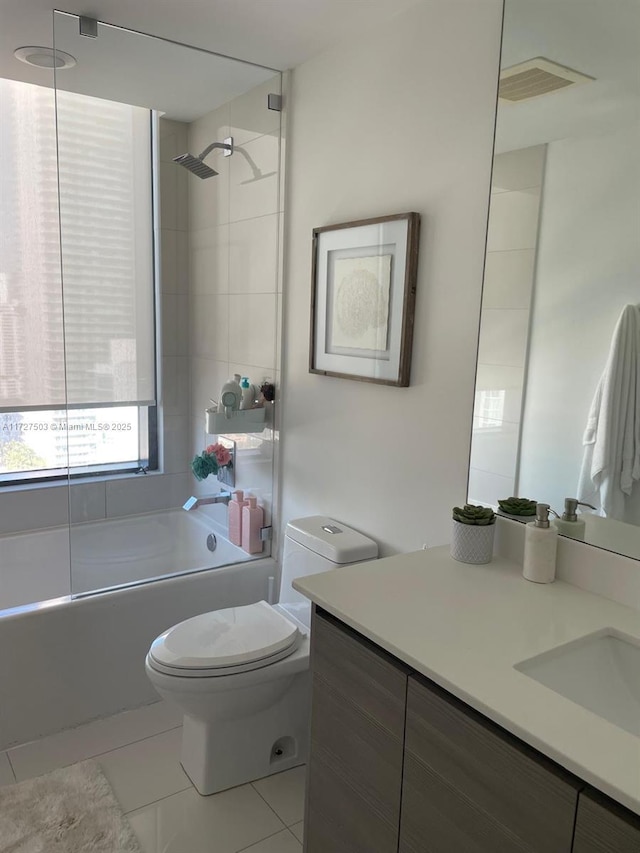 full bathroom featuring tiled shower / bath, tile patterned floors, toilet, and vanity