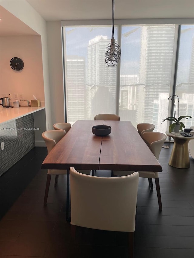 dining area featuring dark hardwood / wood-style flooring and a wall of windows