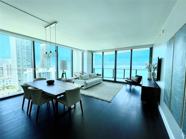 dining area featuring a notable chandelier, dark wood-type flooring, and a wall of windows