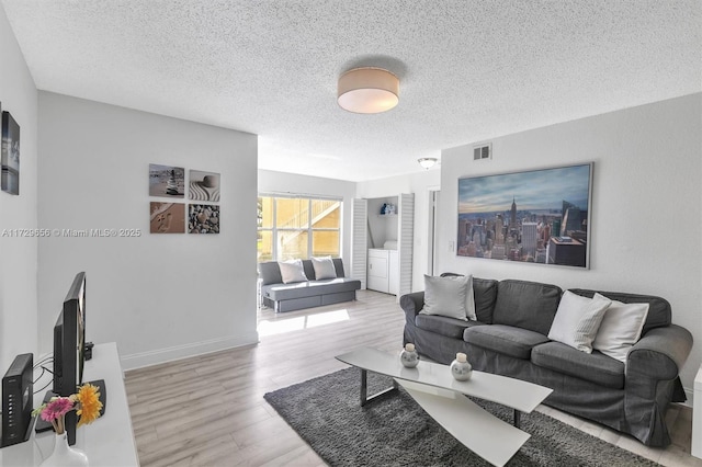 living room featuring light hardwood / wood-style floors and a textured ceiling