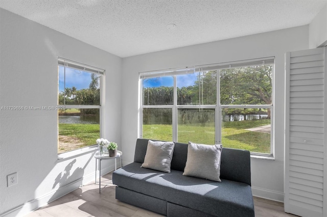 sunroom featuring a water view and a wealth of natural light