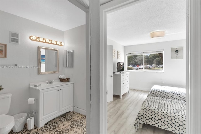 bathroom with vanity, a textured ceiling, and toilet