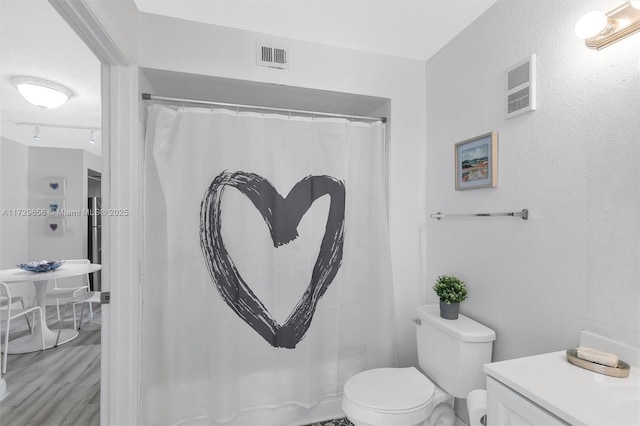 bathroom featuring hardwood / wood-style flooring and toilet