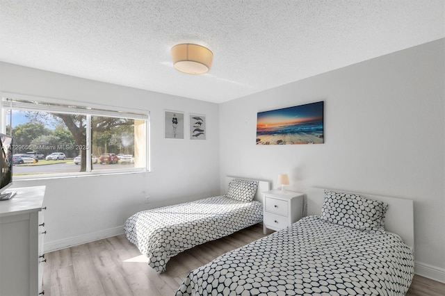 bedroom featuring wood-type flooring and a textured ceiling