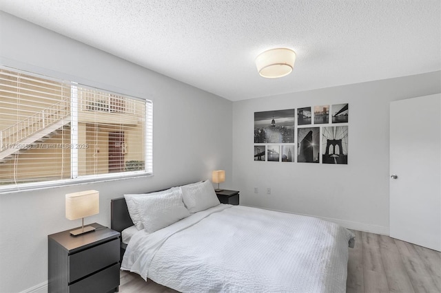 bedroom featuring wood-type flooring and a textured ceiling