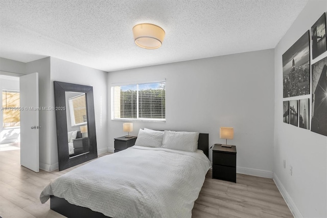 bedroom featuring light hardwood / wood-style flooring and a textured ceiling