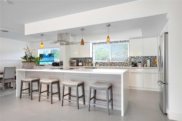 kitchen with hanging light fixtures, island exhaust hood, and white cabinets