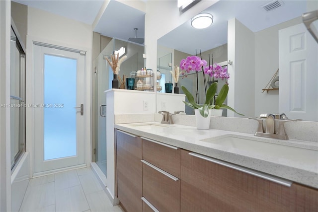 bathroom featuring vanity, combined bath / shower with glass door, and tile patterned floors