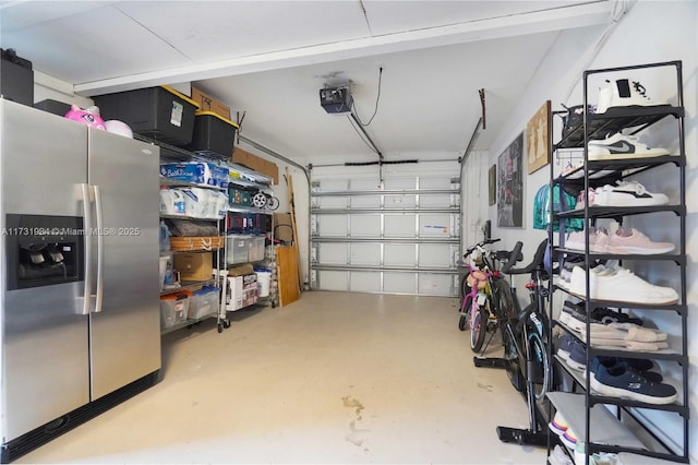 garage featuring a garage door opener and stainless steel fridge