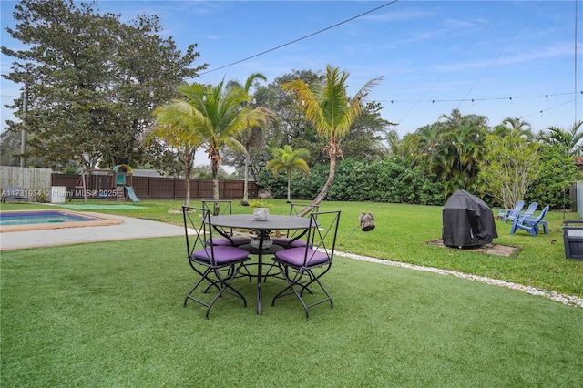 view of yard with a fenced in pool and a playground