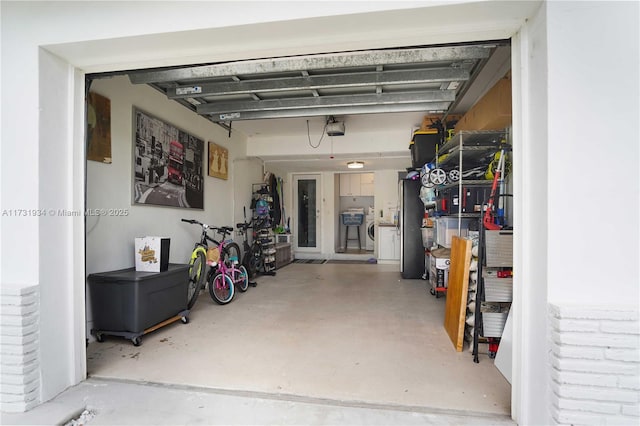 garage featuring a garage door opener and separate washer and dryer