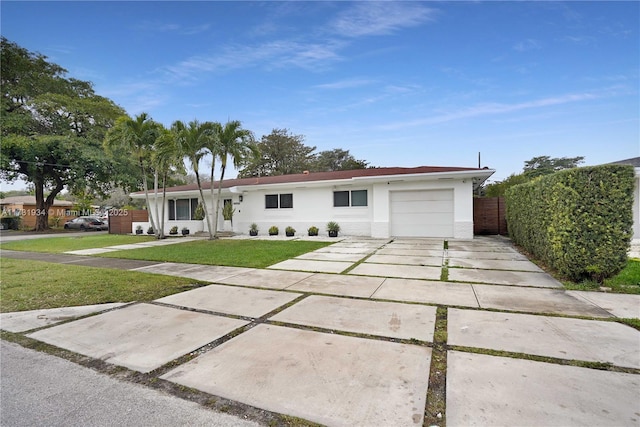 ranch-style home with a garage and a front lawn