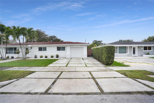 ranch-style house featuring a garage and a front lawn