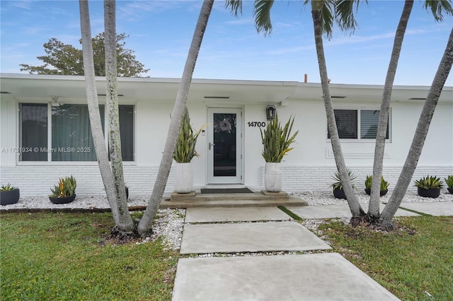 entrance to property with a lawn