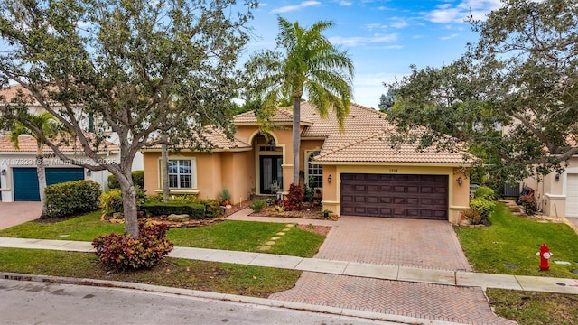 mediterranean / spanish-style home featuring a garage and a front lawn